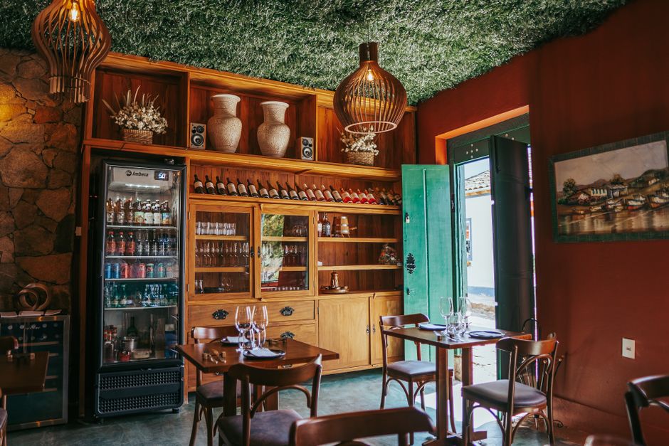 Bar brasileiro aconchegante em Tiradentes com exibição de vinhos e decoração rústica.
